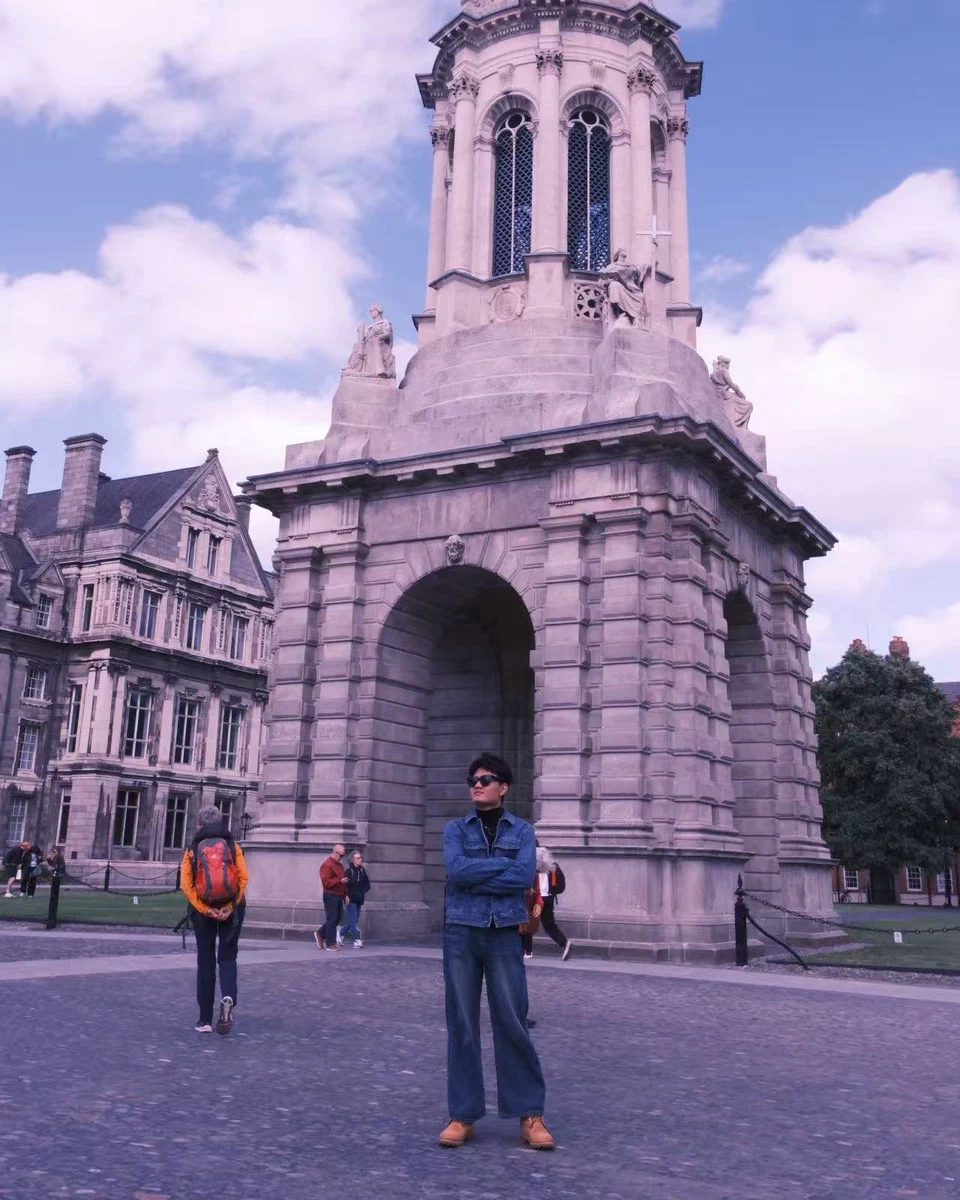 Wenbo Zhang standing in front of a historic university building
